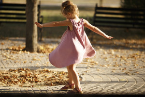 Full length portrait of little girl dancing in the park